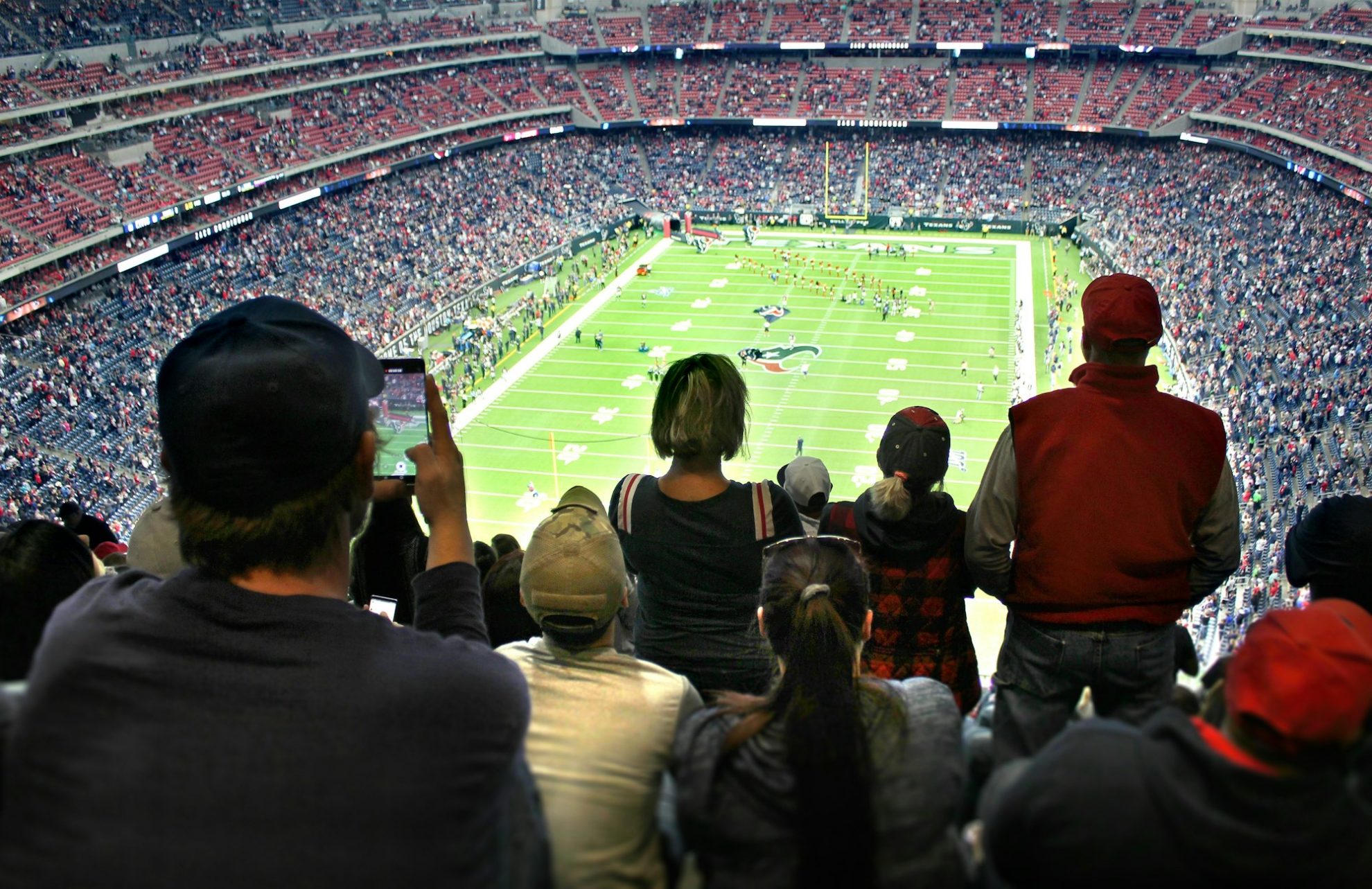 An audience of sports fans watching an NFL football game in a stadium